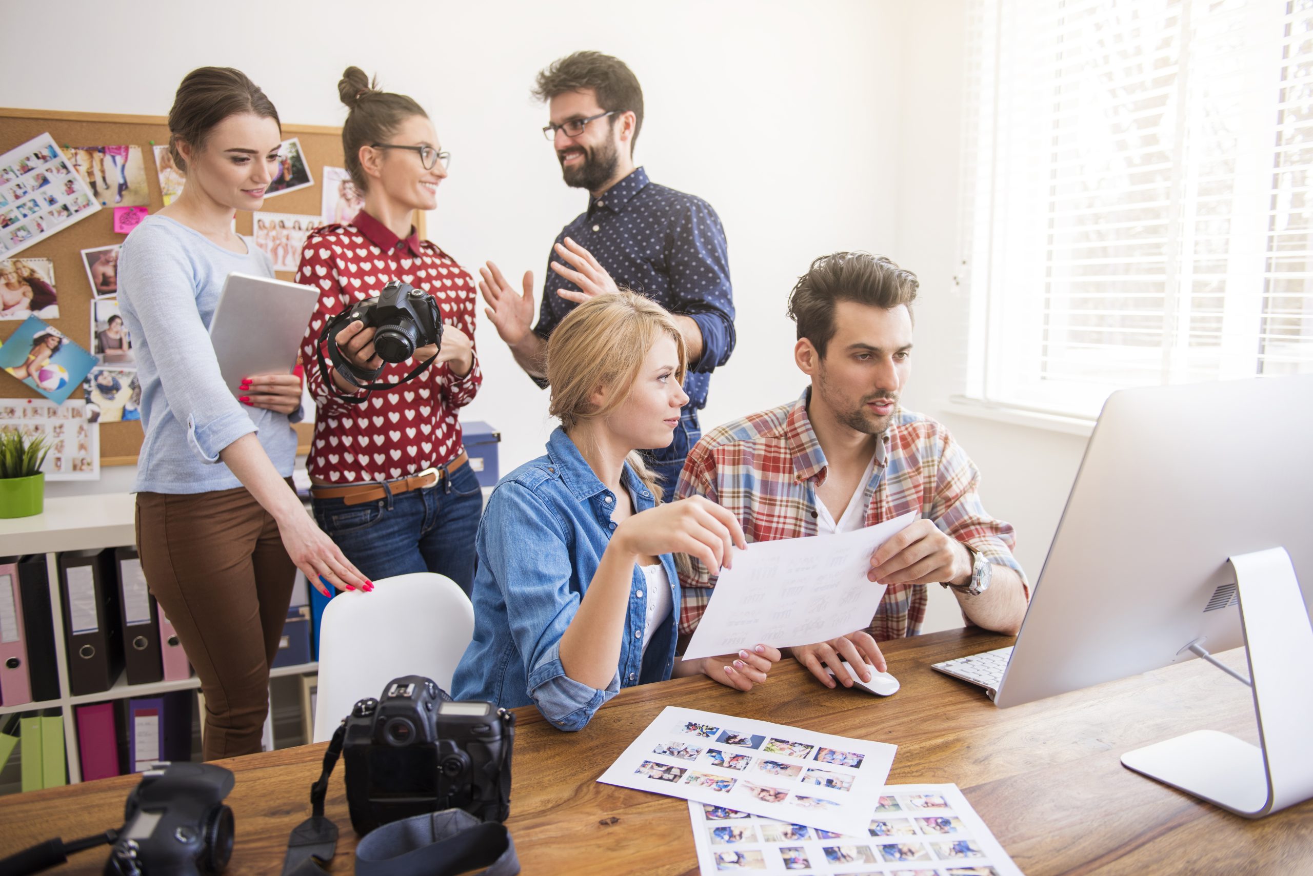 Digital Marketing Agency Dubai Creative team at a digital marketing agency in Dubai brainstorming a visual campaign with cameras and professional design software.